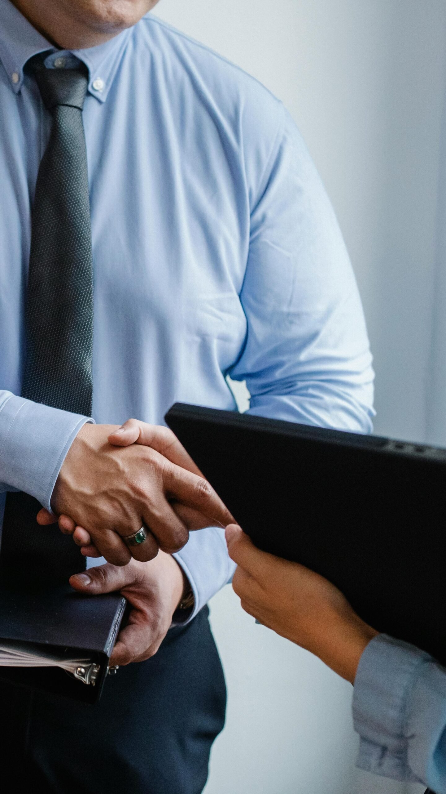 Accueil Business handshake between colleagues in a formal office meeting setting.